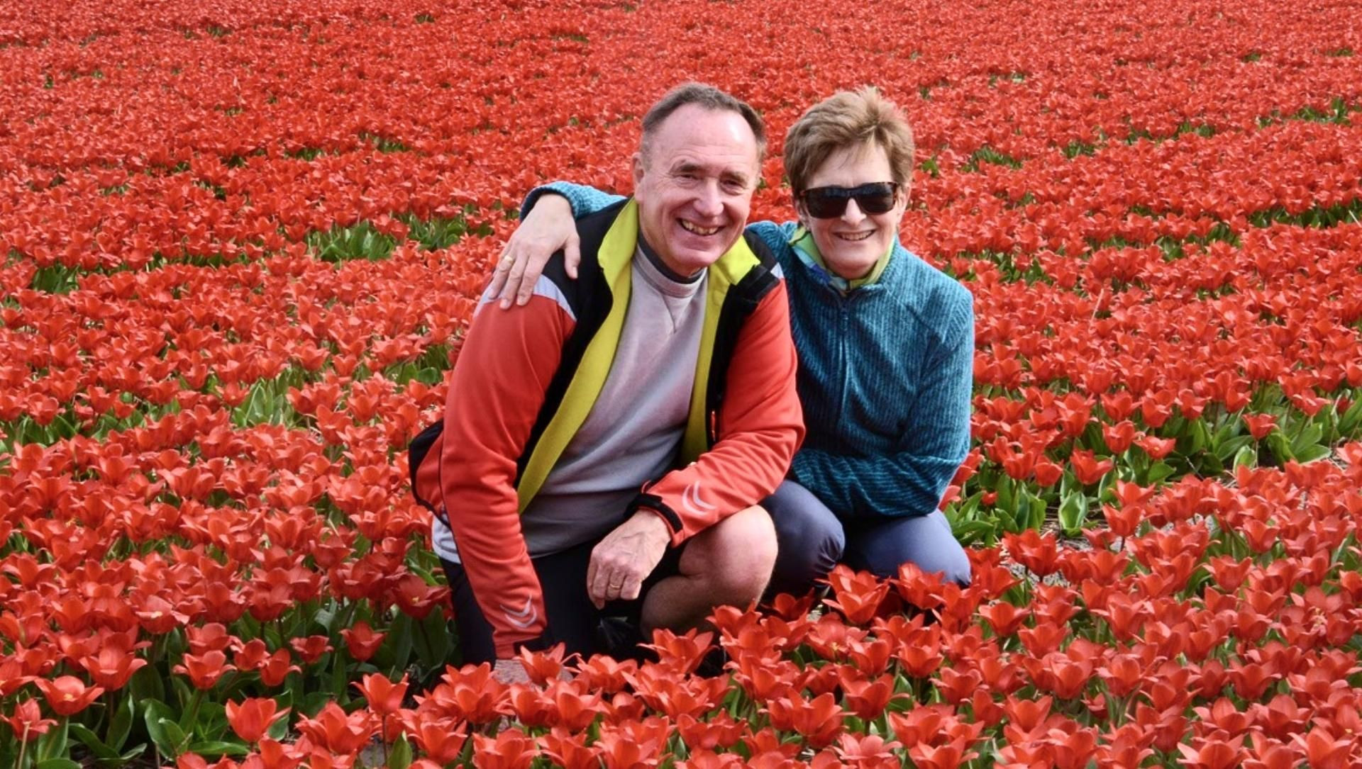 © Jean-Pierre Coston Couple dans un champ de tulipes rouges - Pays-Bas